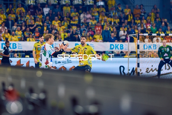 Ein Spieler von Rhein Neckar Löwen verteidigt gegen einen Spieler von SC Magdeburg.