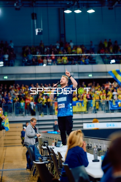 Ein Spieler von Rhein Neckar Löwen jubelt auf einem Tisch stehend vor den Fans.