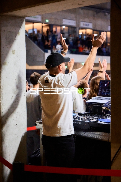 DJ hebt die Arme vor jubelnder Menge