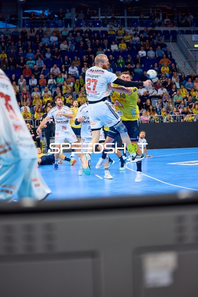 Antonio Metzner von HC Erlangen versucht einen Wurf, während ein Spieler der Rhein Neckar Löwen ihn blockiert.