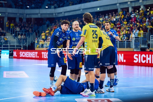 Ein Spieler von Rhein Neckar Löwen hilft einem gefallenen Spieler von ThSV Eisenach auf.