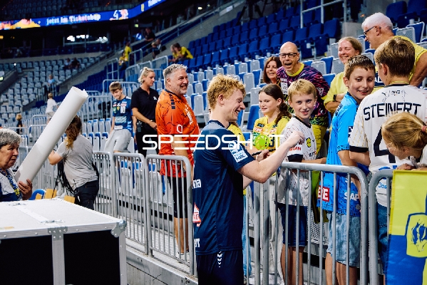 Ein Spieler von Rhein Neckar Löwen gibt Autogramme an Fans.