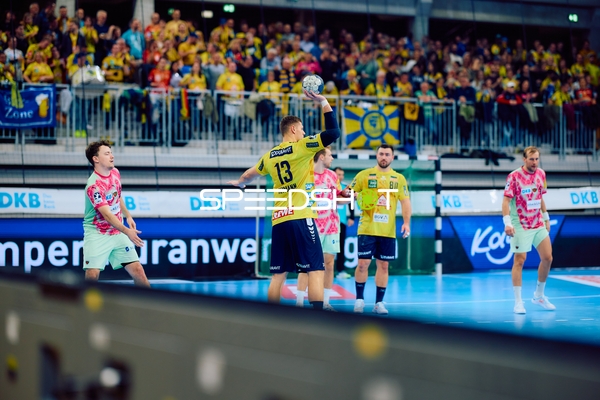 Ein Spieler der Rhein Neckar Löwen in gelbem Trikot bereitet sich darauf vor, den Ball zu werfen.