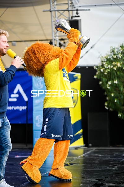 Das Maskottchen Conny der Rhein-Neckar Löwen hebt einen Pokal in die Luft.