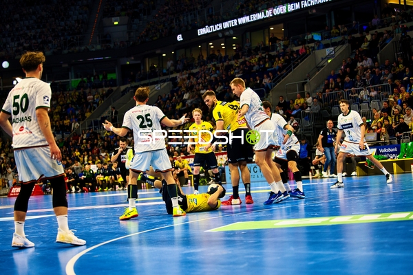 Ein Spieler von Rhein Neckar Löwen liegt auf dem Boden, während ein Spieler von HSG Wetzlar verteidigt.