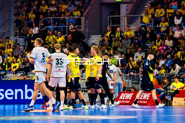 Spieler auf dem Spielfeld während einer Handballpartie, möglicherweise in Vorbereitung auf eine Spielaktion.