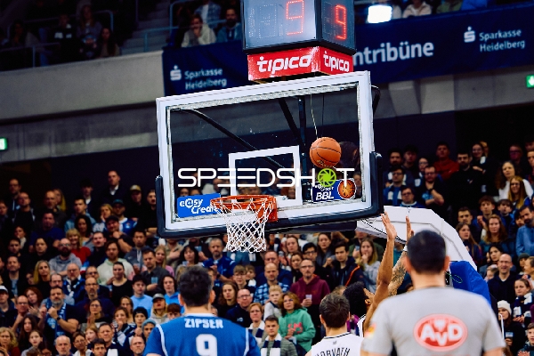 Der Ball ist im Begriff, in den Korb zu gehen, während Spieler unter dem Korb zu sehen sind.