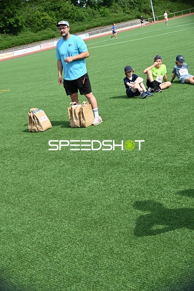 Trainer und Kinder auf dem Sportplatz