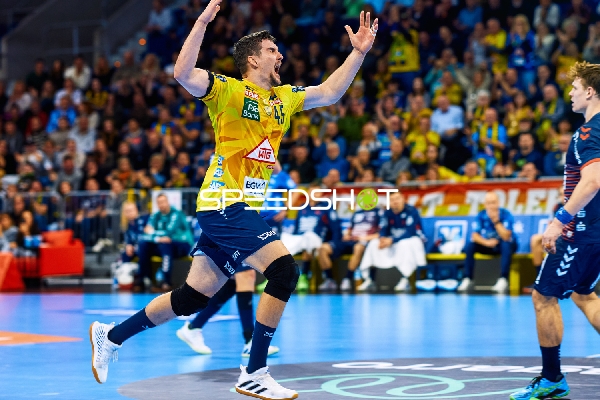 Ein Spieler der Rhein Neckar Löwen jubelt mit erhobenen Armen.