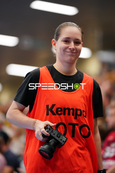 Person mit Kamera in oranger Weste