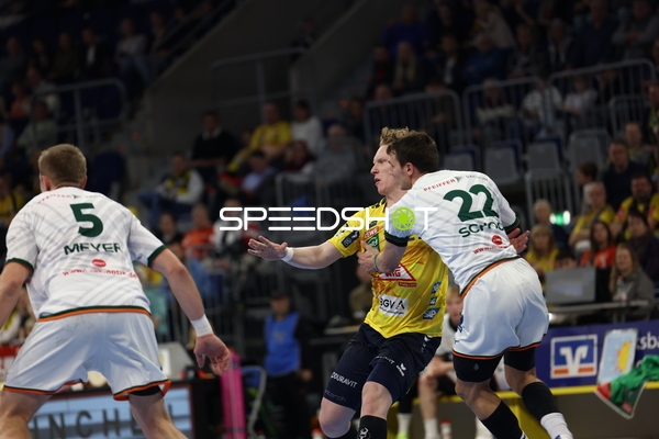 Ein Spieler der Rhein Neckar Löwen versucht, an zwei Verteidigern von HSG Wetzlar vorbeizukommen.