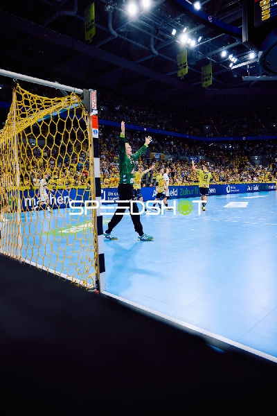 Ein Torwart steht im Tor, bereit einen Wurf abzuwehren.