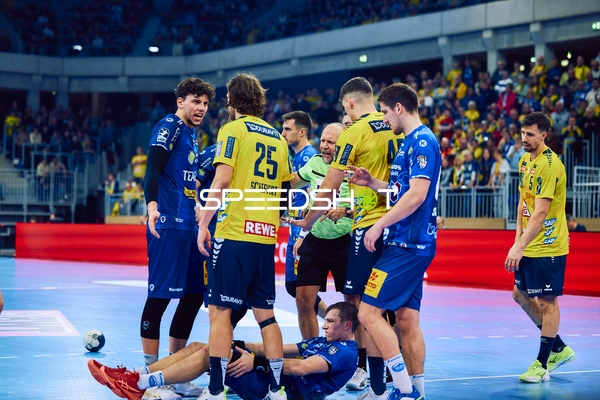 Eine Spielsituation, bei der ein Spieler auf dem Boden liegt und andere Spieler diskutieren.