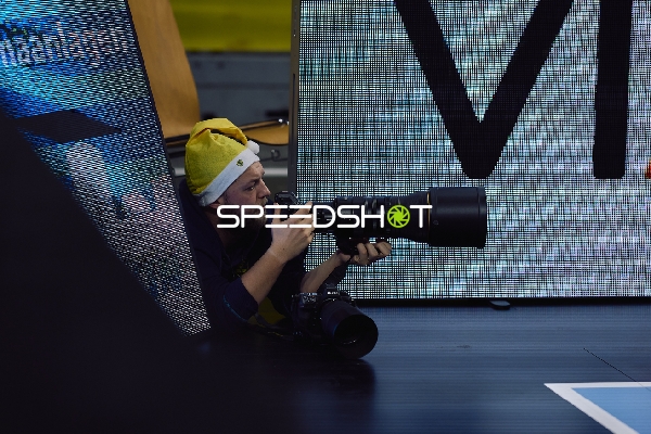 Ein Fotograf liegt am Spielfeldrand und fotografiert das Spiel.