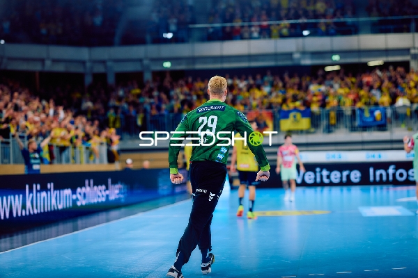 Ein Spieler der Rhein Neckar Löwen läuft in Richtung Spielfeld, während die Zuschauer jubeln.