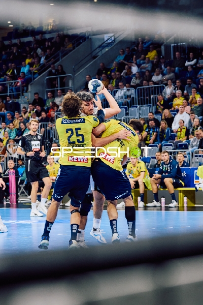 Zwei Spieler von Rhein Neckar Löwen versuchen, den Ballbesitzer von HSV Hamburg am Torschuss zu hindern.