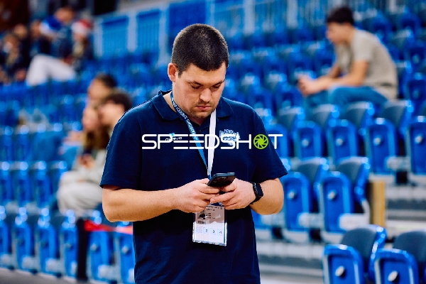 Eine Person steht alleine und schaut auf sein Handy.