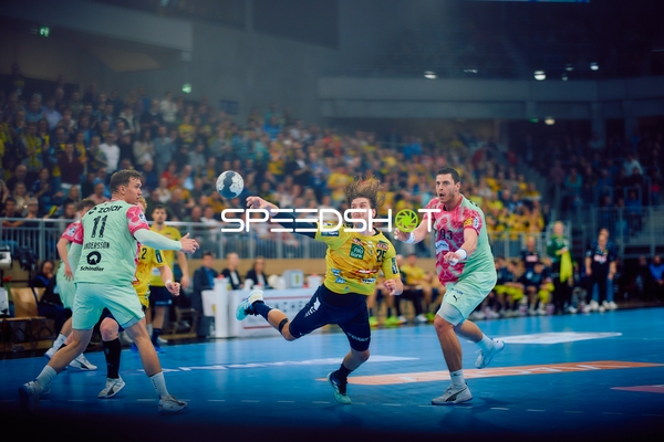 Ein Spieler der Rhein Neckar Löwen versucht einen Wurf, während ein Spieler der Füchse Berlin verteidigt.