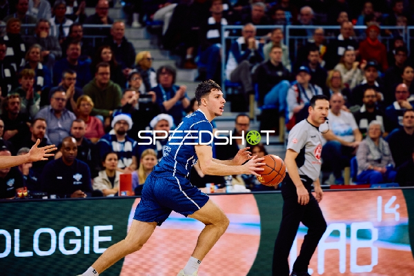Ein Basketballspieler dribbelt den Ball auf dem Spielfeld.