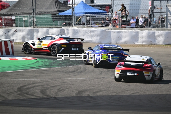 Drei Rennfahrzeuge in Kurve