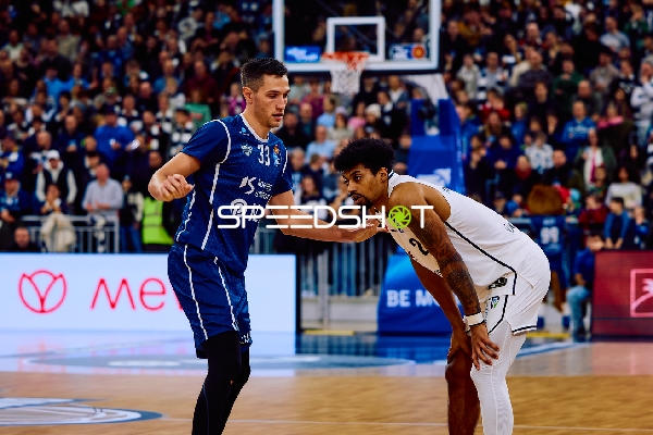 Spieler von MLP Academics Heidelberg und Brose Bamberg interagieren auf dem Spielfeld.