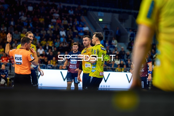 Spieler von Rhein Neckar Löwen diskutieren mit einem Spieler der SG Flensburg Handewitt.