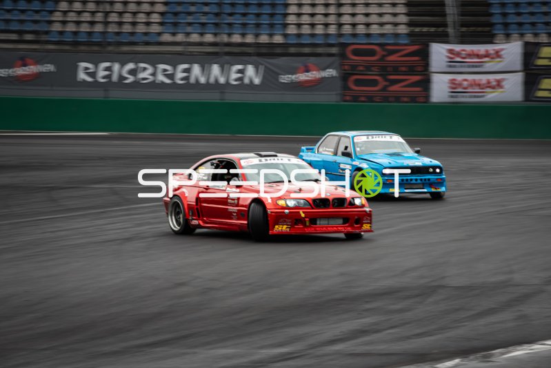 Roter BMW E46 und blauer BMW E30 im Tandem-Drift beim Reisbrennen