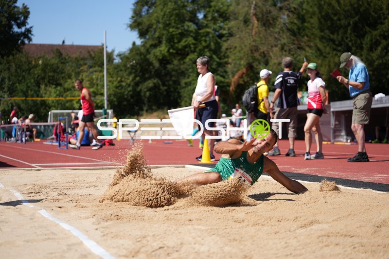 Weitsprung im Sandkasten – Athletin im Flug