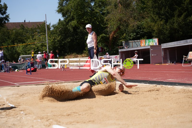 Weitsprung im Sand – Athlet bei der Landung