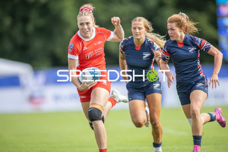 Dänemark-Spielerin mit Ball flieht vor Great-Britain-Verteidigerinnen