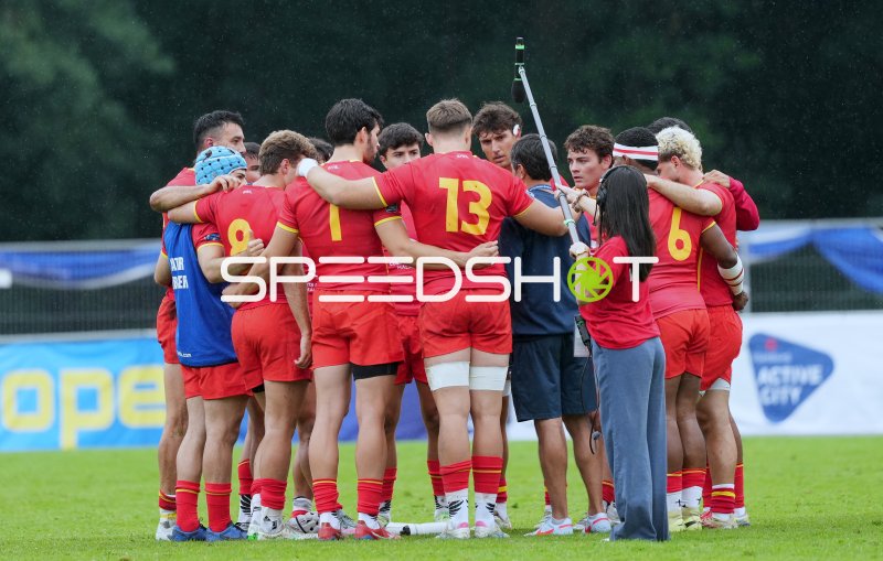 Rugby-Team in geschlossener Mannschaftsbesprechung im Regen