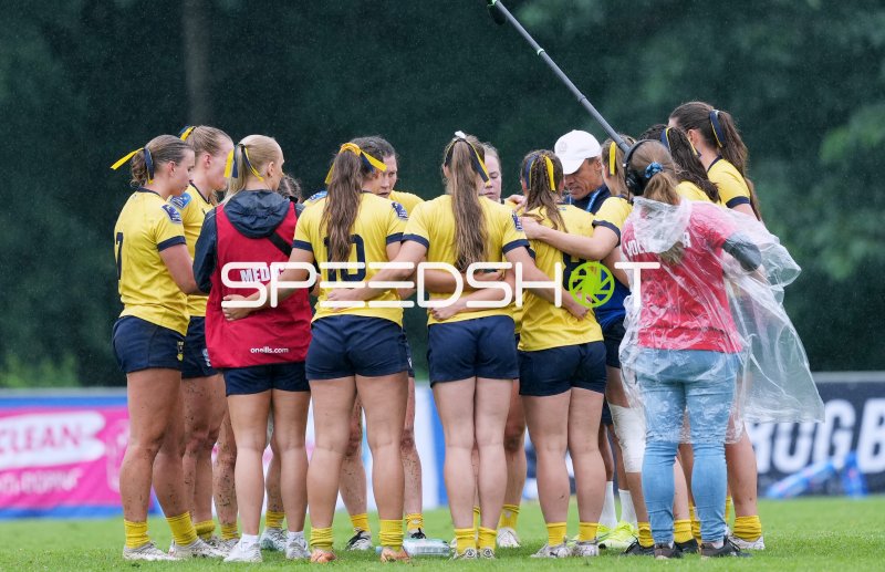 Frauenrugby-Team in Mannschaftsbesprechung im Regen