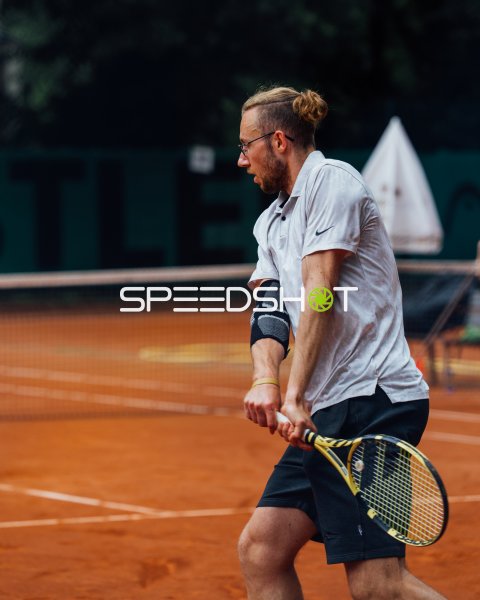 Tennisspieler mit Babolat-Schläger im Aufschlag-Moment auf Sand