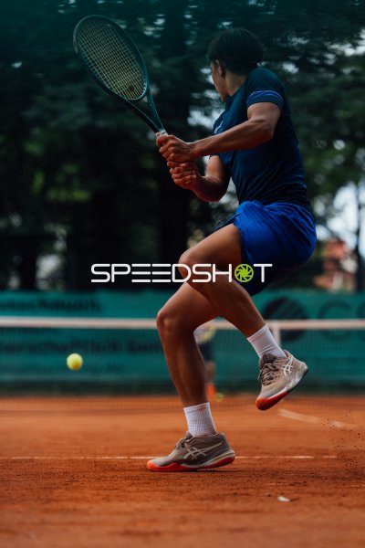 Tennisspieler beim beidhändigen Rückhand-Schlag auf Sandplatz in Dresden