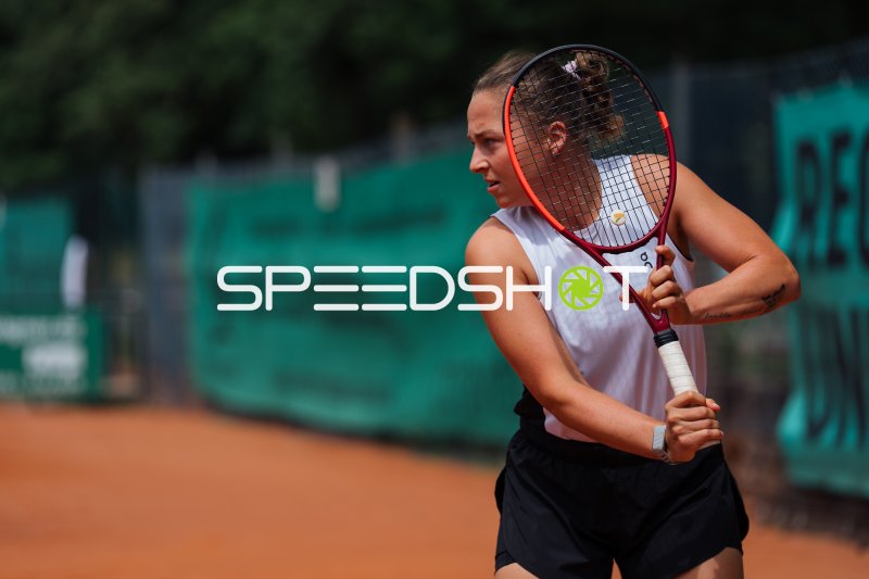 Tennisspielerin mit Schläger in Bereitschaftsposition auf Sandplatz