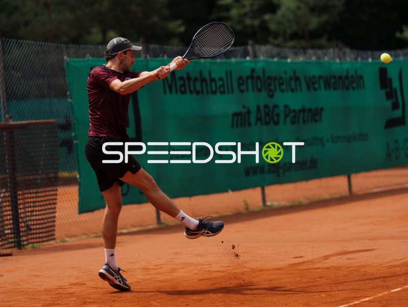 Tennisspieler beim kraftvollen Rückhand-Schlag auf Sandplatz in Dresden