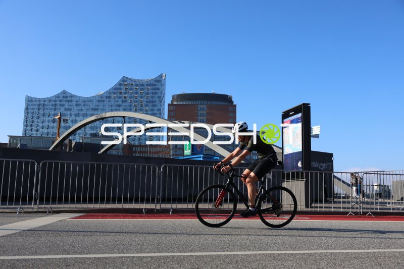 Radfahrer beim Triathlon-Radabschnitt vor der Elbphilharmonie Hamburg