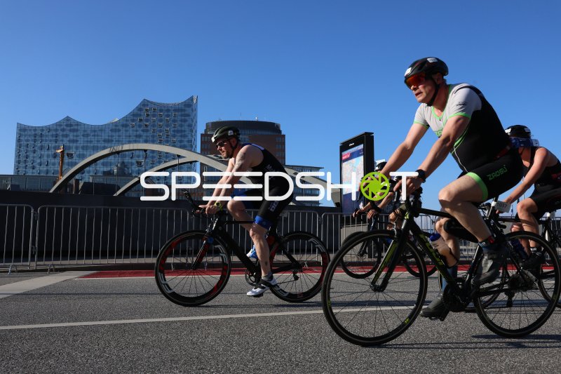 Triathleten auf der Radstrecke am Jungfernstieg mit Elbphilharmonie im Hintergrund