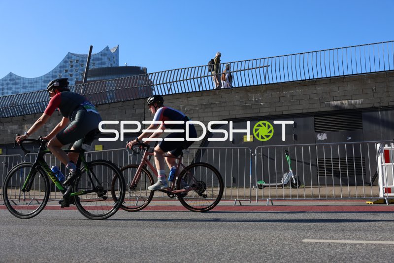 Zwei Triathleten auf der Radstrecke vor der Elbphilharmonie in Hamburg
