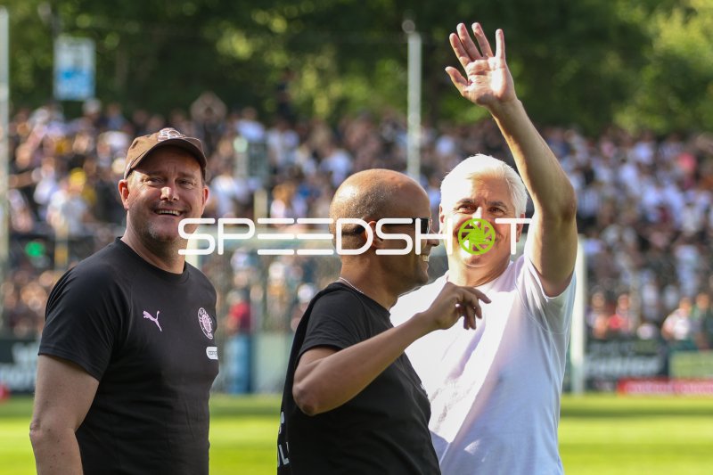 Drei Personen winken den Fans im Karl-Liebknecht-Stadion zu
