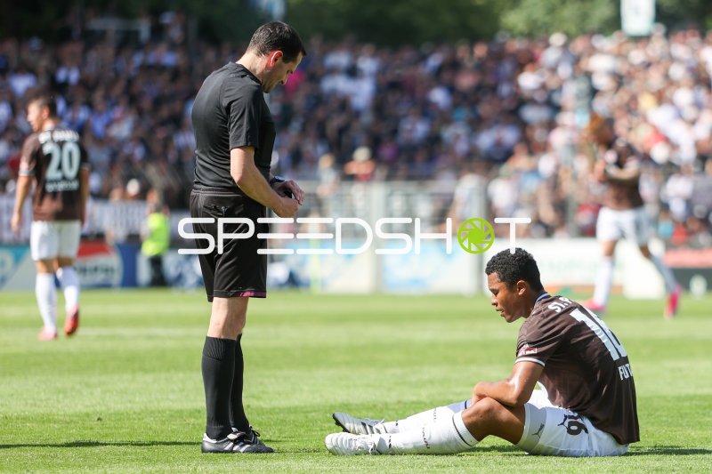 Taichi Hara (#18; FC St. Pauli) am Boden – Schiedsrichter schaut zu