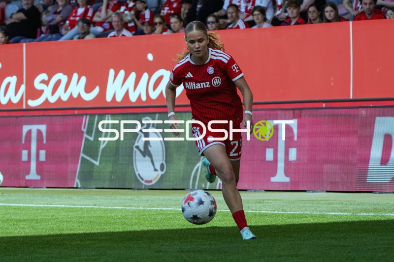 Fußballspielerin im roten Trikot dribbelt den Ball