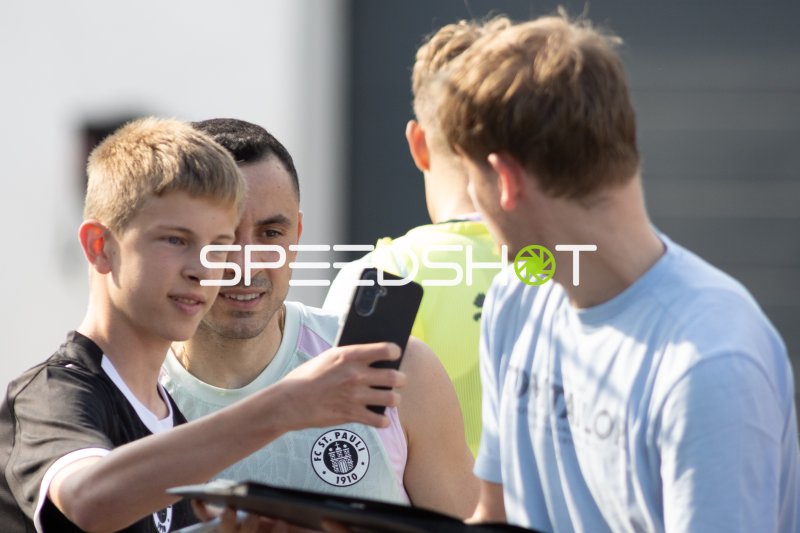 Manos Saliakas (#2 FC St. Pauli) beim Selfie mit Fans am Trainingszentrum