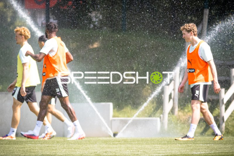 FC St. Pauli Spieler beim Training mit aktivem Rasensprenger