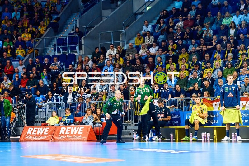 Spieler auf der Ersatzbank und Trainer analysieren das Spiel.