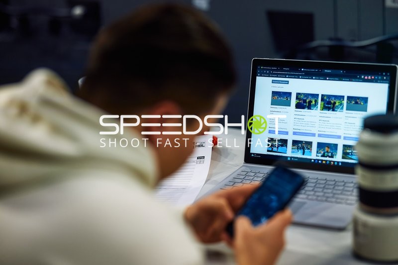 Eine Person betrachtet eine Website auf einem Laptop und betrachtet ein Handy.