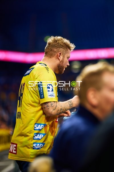 Ein Spieler im Trikot der Rhein Neckar Löwen steht am Spielfeldrand.