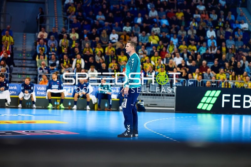 Ein Spieler von SG Flensburg beobachtet das Spielgeschehen vom Spielfeldrand.