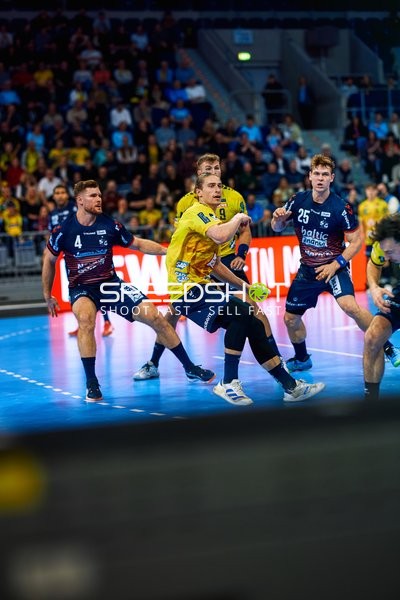 Ein Spieler von Rhein Neckar Löwen schießt auf das Tor, während Spieler von SG Flensburg Handewitt verteidigen.