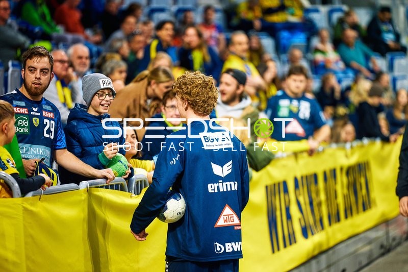 Ein Spieler gibt einem Fan ein Autogramm.